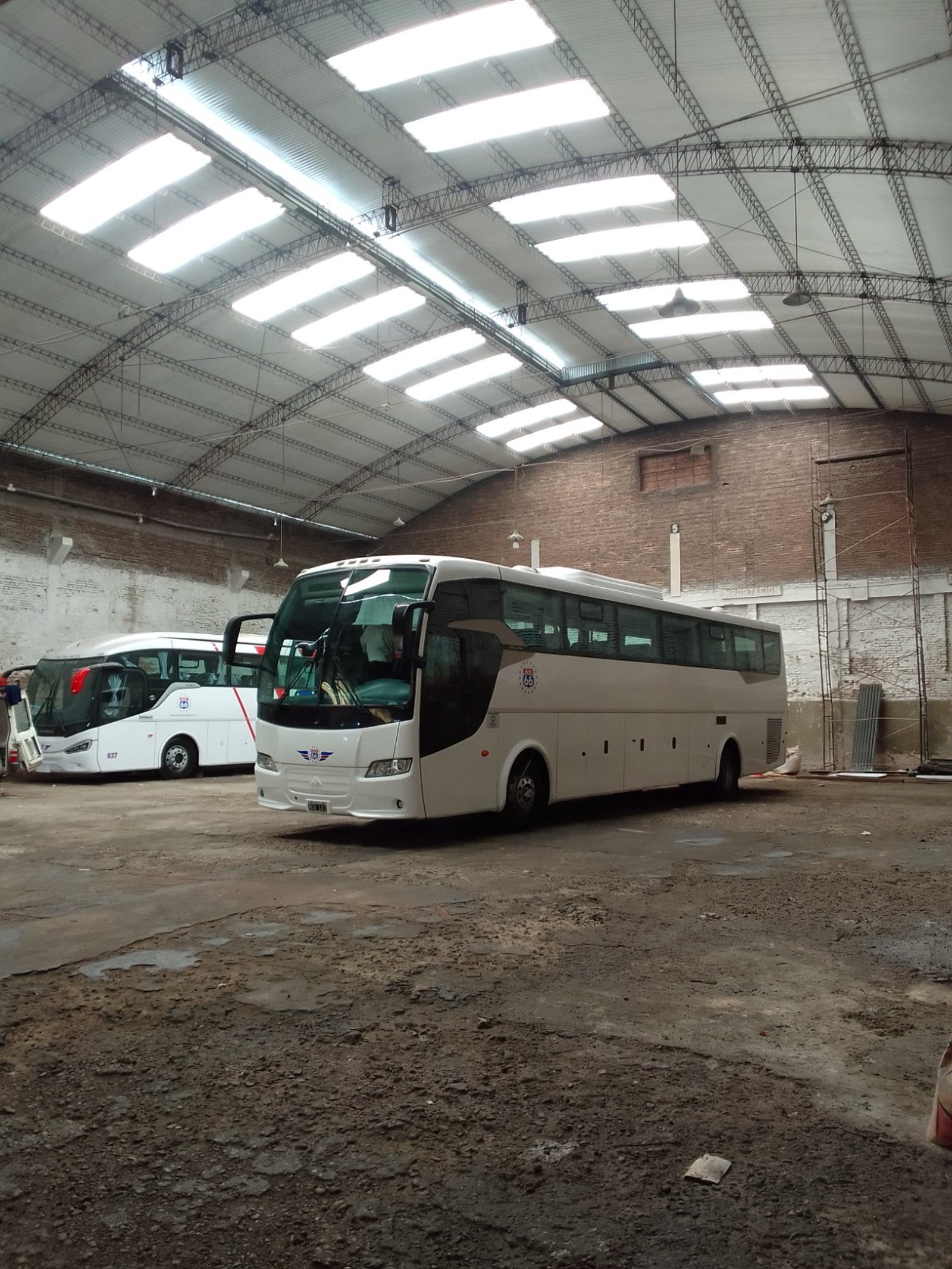 interior de galpão industrial com ônibus e telhado metálico — projeto Galpon en Avellaneda, por Arquitecto Guido Niccoli, em Avellaneda